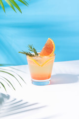 Cold and refreshing orange punch cocktail with orange slice on color background. summer drink.