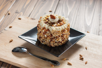 round almond cream cake on wood background