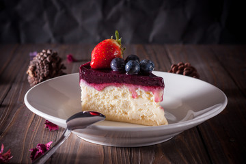 Blueberry cheesecake decorate with pinecorn and dry flower on wood board