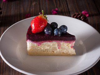 Blueberry cheesecake decorate with pinecorn and dry flower on wood board