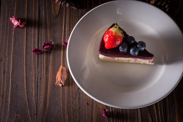 Blueberry cheesecake decorate with pinecorn and dry flower on wood board
