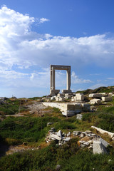 Iconic and unique Temple of Apollon or Portara (Gate) with breathtaking views to port - town and castle of Naxos island and the Aegean blue sea, Cyclades, Greece