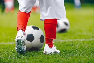 Legs of child in training practice soccer. Kid imprrove dribbling skills on football pitch. Soccer training for children