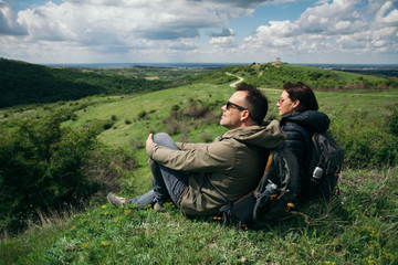 Fototapeta na wymiar Couple of hikers sitting on the mountain top