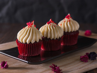 red velvet cupcakes with cream cheese icing decorate with dry fl