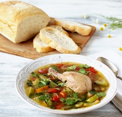 Vegetable soup with chicken in a white plate on a light background. Soft focus. Place for text. Copy Space