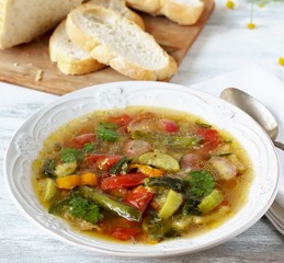 Vegetable soup in a white plate on a light background. Soft focus.