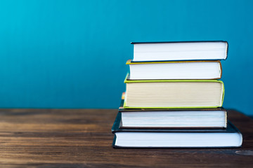 Books on table in front of chalk board. Back to school concept with copy space for text