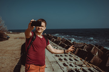 Adult man travel the world. Happy and confident businessman taking selfie on vacation. Tourist with smartphone. Tourism concept. Odessa seaview. Explore Ukraine. Black Sea background. Copy space