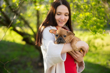 young woman with a little puppy in her arms
