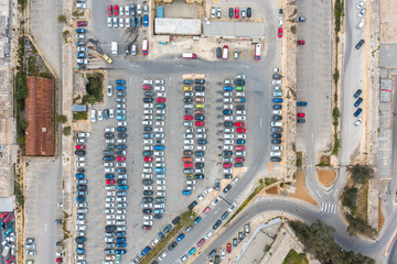 Parking of cars and buses, with roads and a stop in the city, aerial top view.