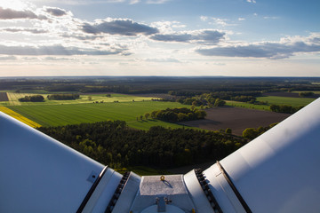 Agricultural landscape seen from the top of a wind turbine between the rotor blades
