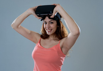 Portrait of cheerful young woman about to use Virtual Reality goggles for first time
