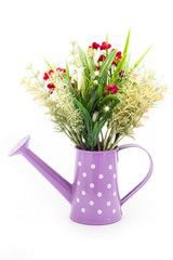 Plastic flower decorate in watering can isolated on white background