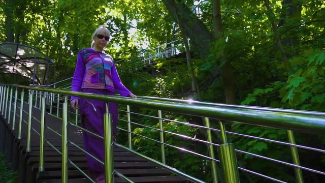 Woman walking down the stairs in the park. Slow motion