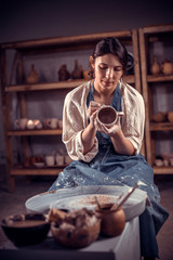 Beautiful craftsman at his wheel creating a new masterpiece. The concept of craft creativity.