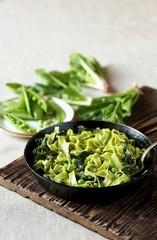 green fettuccine pasta with spinach leaves and green peas. ready meals, vegetarian cuisine. Italian food.
