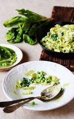 the process of eating pasta fettuccine with spinach leaves and green peas. Dirty dishes. vegetarian cuisine. Italian food.
