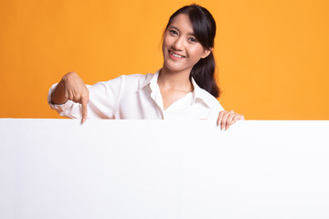 Fototapeta premium Young Asian woman point to a blank sign.