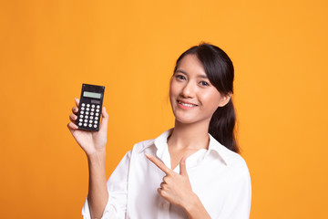 Asian woman point to  calculator.
