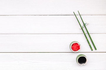 asian cuisine set with bamboo sticks, soy sauce and ginger for sushi and maki on white wooden background top view mockup
