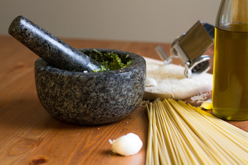 Pesto genovese prepared in a stone mortar with spaghetti, oil and garlic