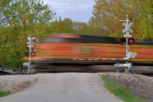 Freight train blurred  in motion at crossing gate