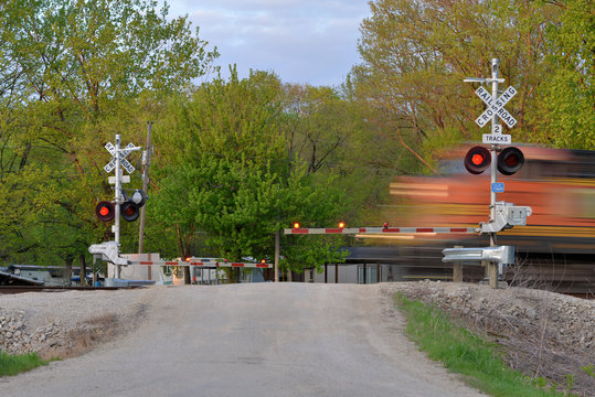 Freight train blurred  in motion at crossing gate