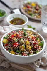 Fresh quinoa tabbouleh salad with tomatoes, peppers and cucumbers