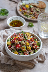 Fresh quinoa tabbouleh salad with tomatoes, peppers and cucumbers