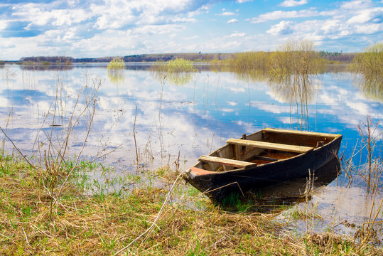 Old wooden boat near the river. Spring flood © Павел Страхов
