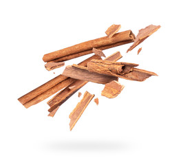 Cinnamon sticks crushed in the air isolated on white background