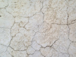 creamy concrete wall covered in scratches and bumblebees, painted white, bacground texture