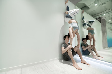 Husband supporting girlfriend doing arm stand on his knees