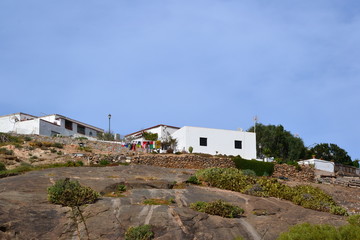 Fototapeta na wymiar Betancuria, Fuerteventura, Spain. House located on the rocks and colorful laundry drying on strings