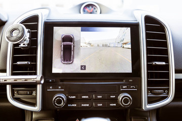 Display in interior of luxury car shows working of front camera in surround 360 degrees view assist...