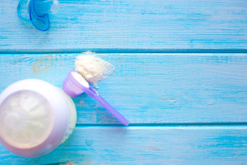 Composition with feeding bottle of baby milk formula on wooden table