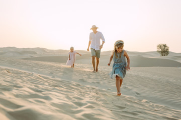 Father with two daughters in the desert in Dubai