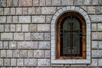 Fototapeta na wymiar a window on the Orthodox church with a stone wall