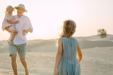 Father with two daughters in the desert in Dubai