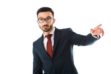 serious businessman in glasses pointing with finger and looking at camera isolated on white