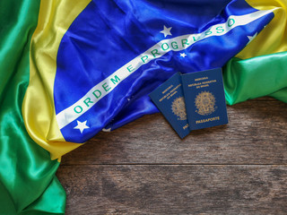 Brazilian flag with Brazilian passport and wooden background