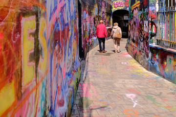 Couple walking in graffiti street, Ghent, Belgium, Europe 