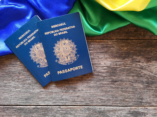Brazilian flag with Brazilian passport and wooden background