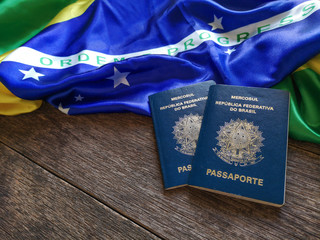 Brazilian flag with Brazilian passport and wooden background