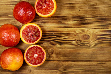 Red blood oranges on wooden table. Top view