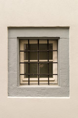 Window with iron grating and white wall