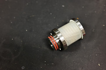 Part of a metal air filter laid on the table.