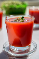 Red tomato juice in a glass, bright morning sun, healthy breakfast