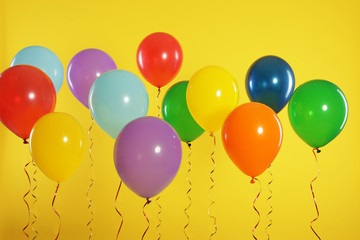 Bright balloons on color background. Celebration time